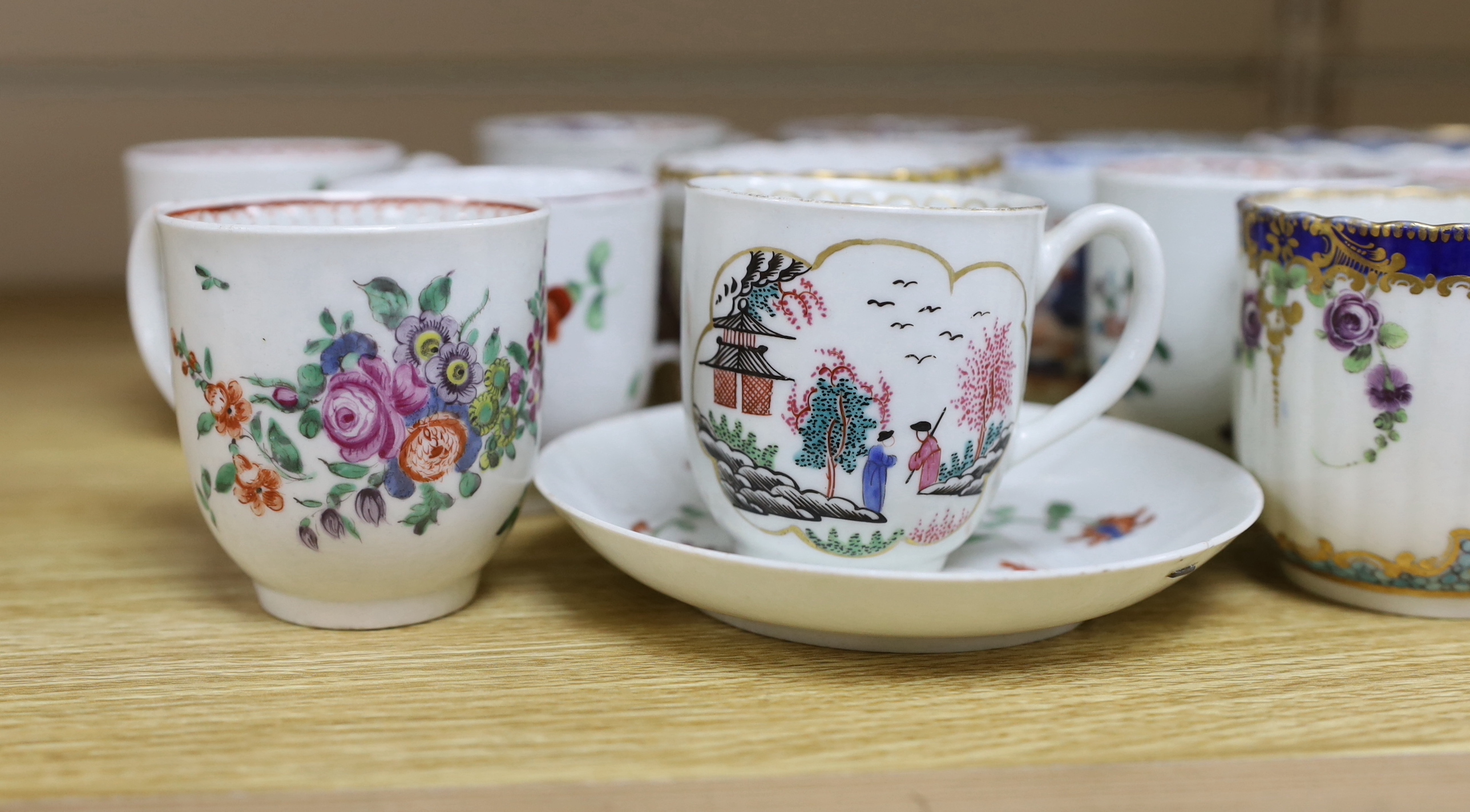 A collection of late 18th century Worcester and Lowestoft coffee cups and a saucer, many hand painted with flowers, the largest 12cm in diameter